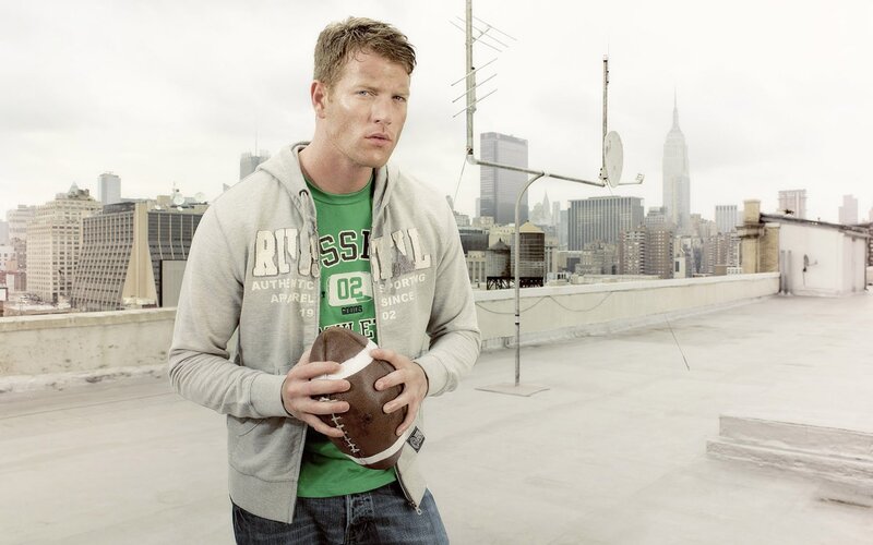 man holding football on rooftop