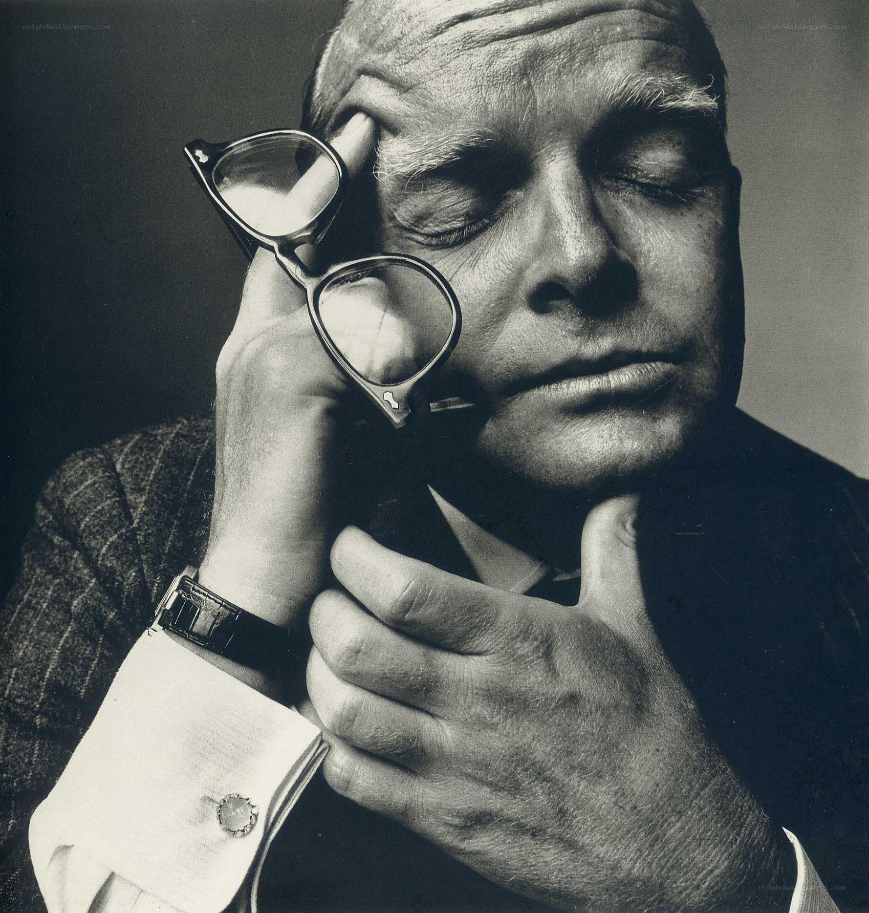 man holding glasses in thought