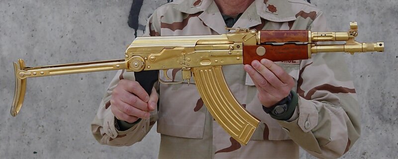Man holding gold-plated rifle