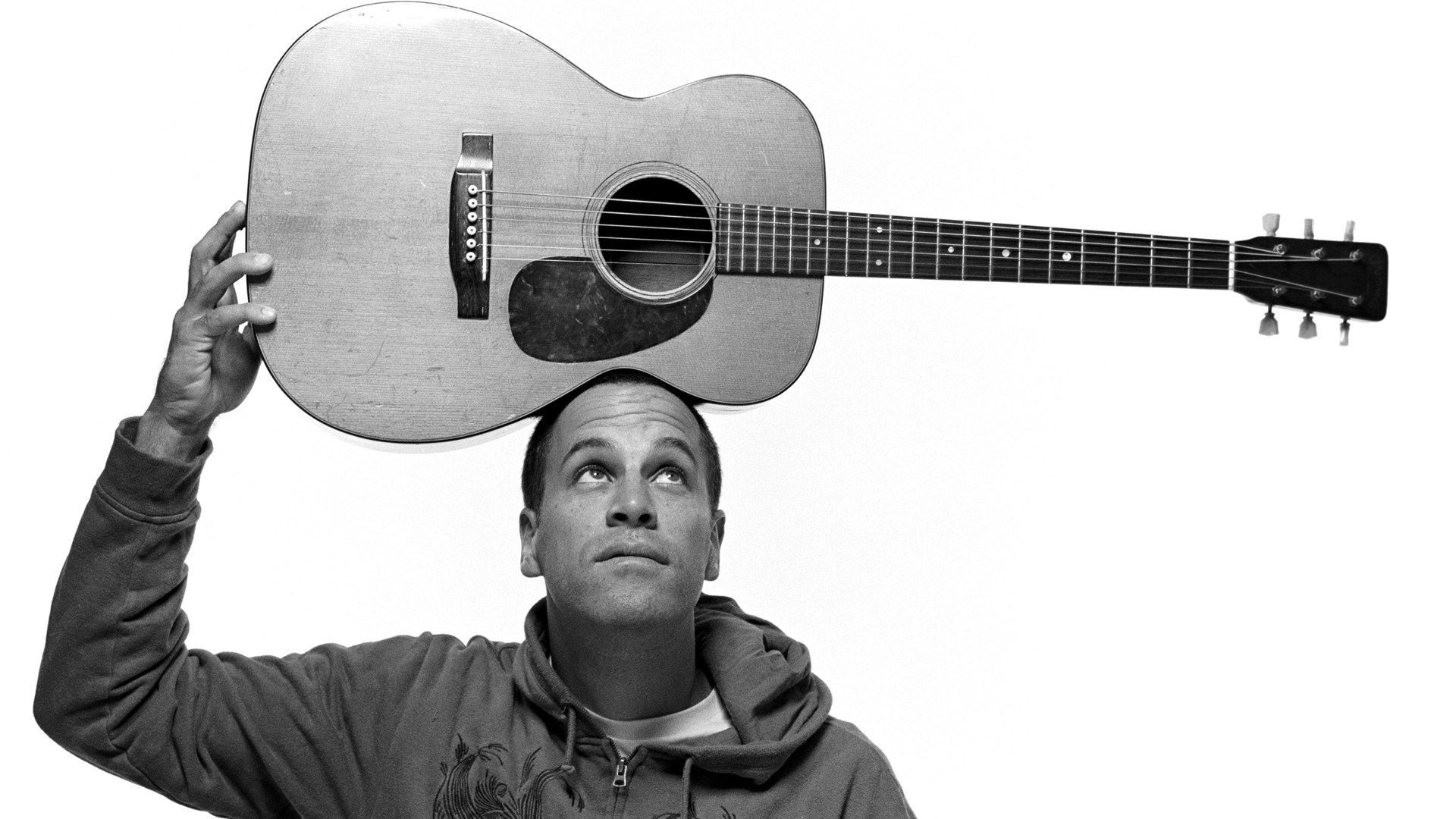 man holding guitar above head