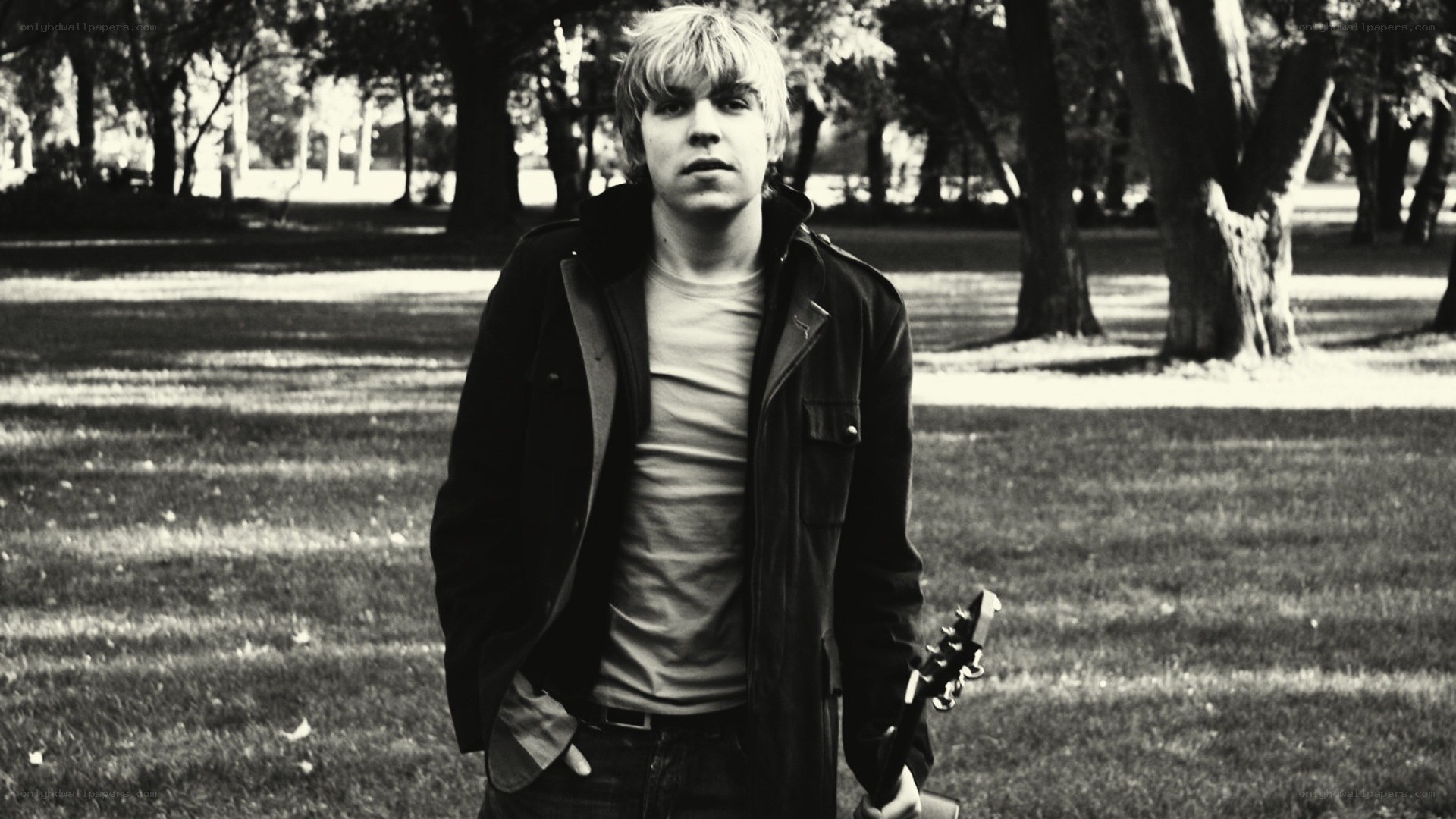 man holding guitar in park