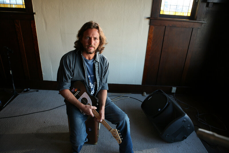 man holding guitar in room