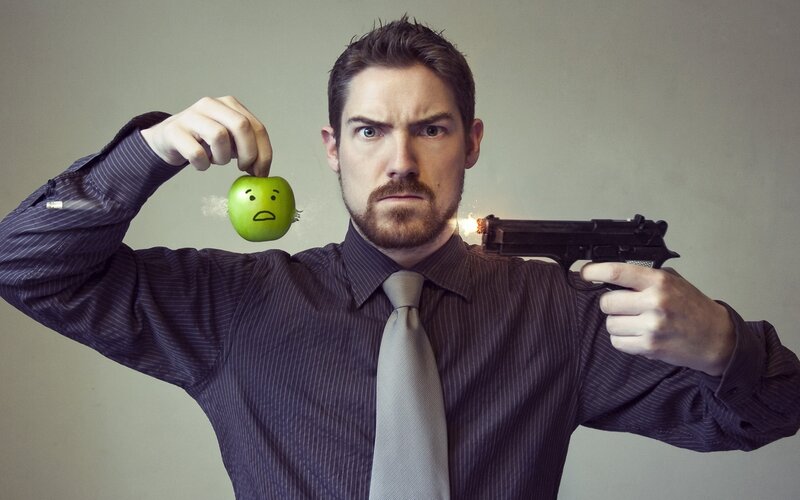 man holding gun and apple