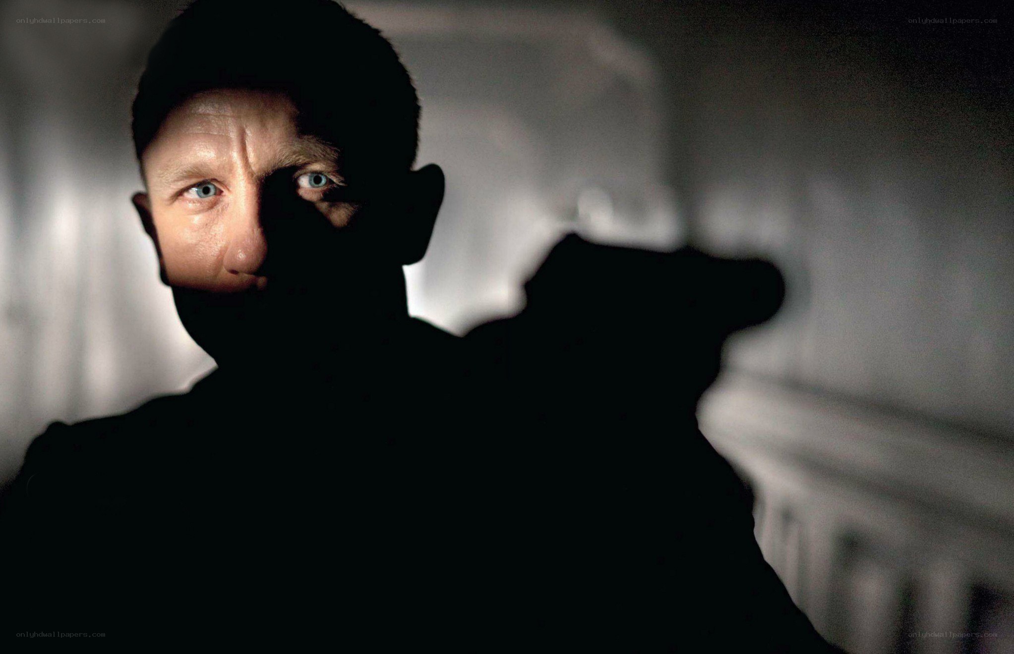 man holding gun in shadow