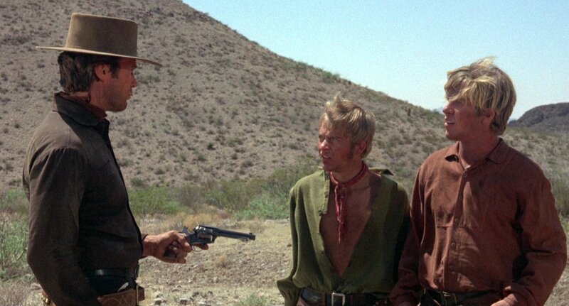 Man Holding Gun to Two Others