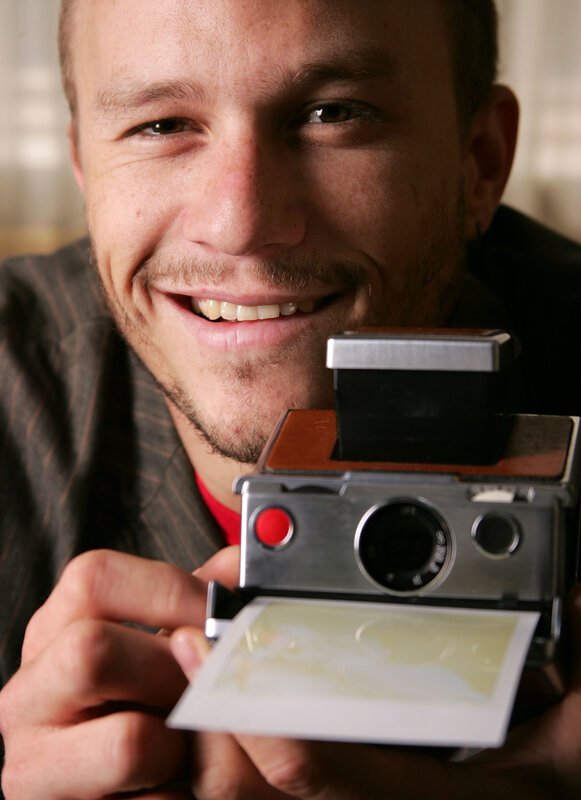 man holding instant camera