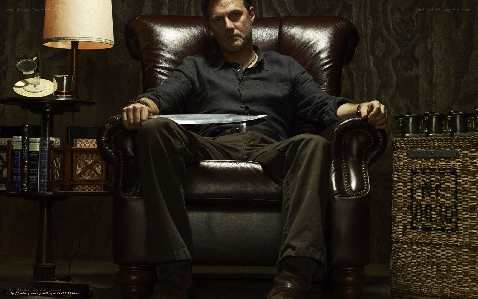 Man holding knife in leather chair
