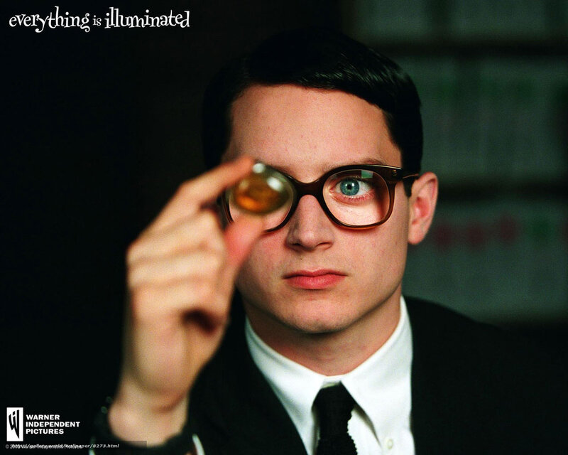 man holding lens in front of eye