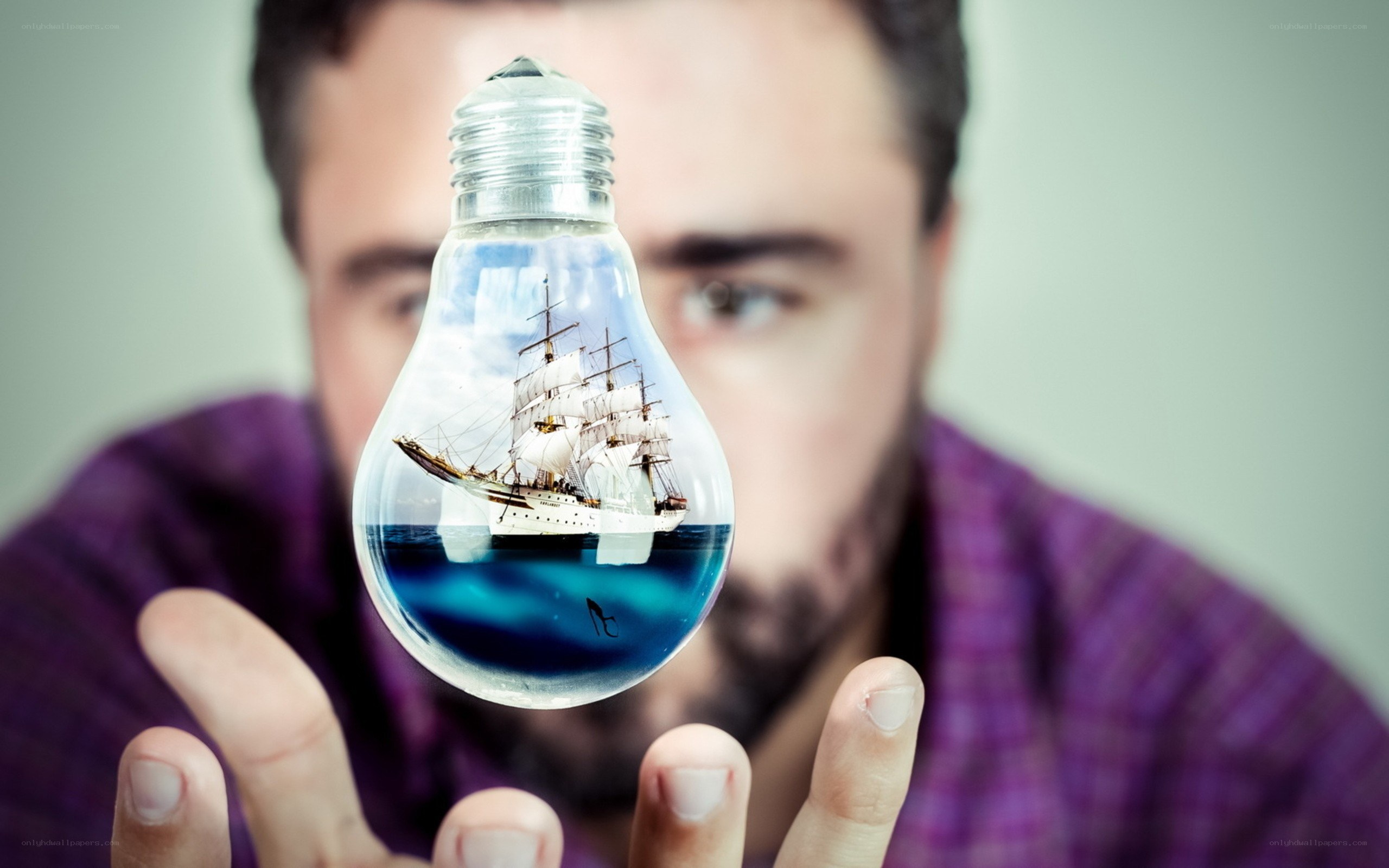man holding light bulb with ship