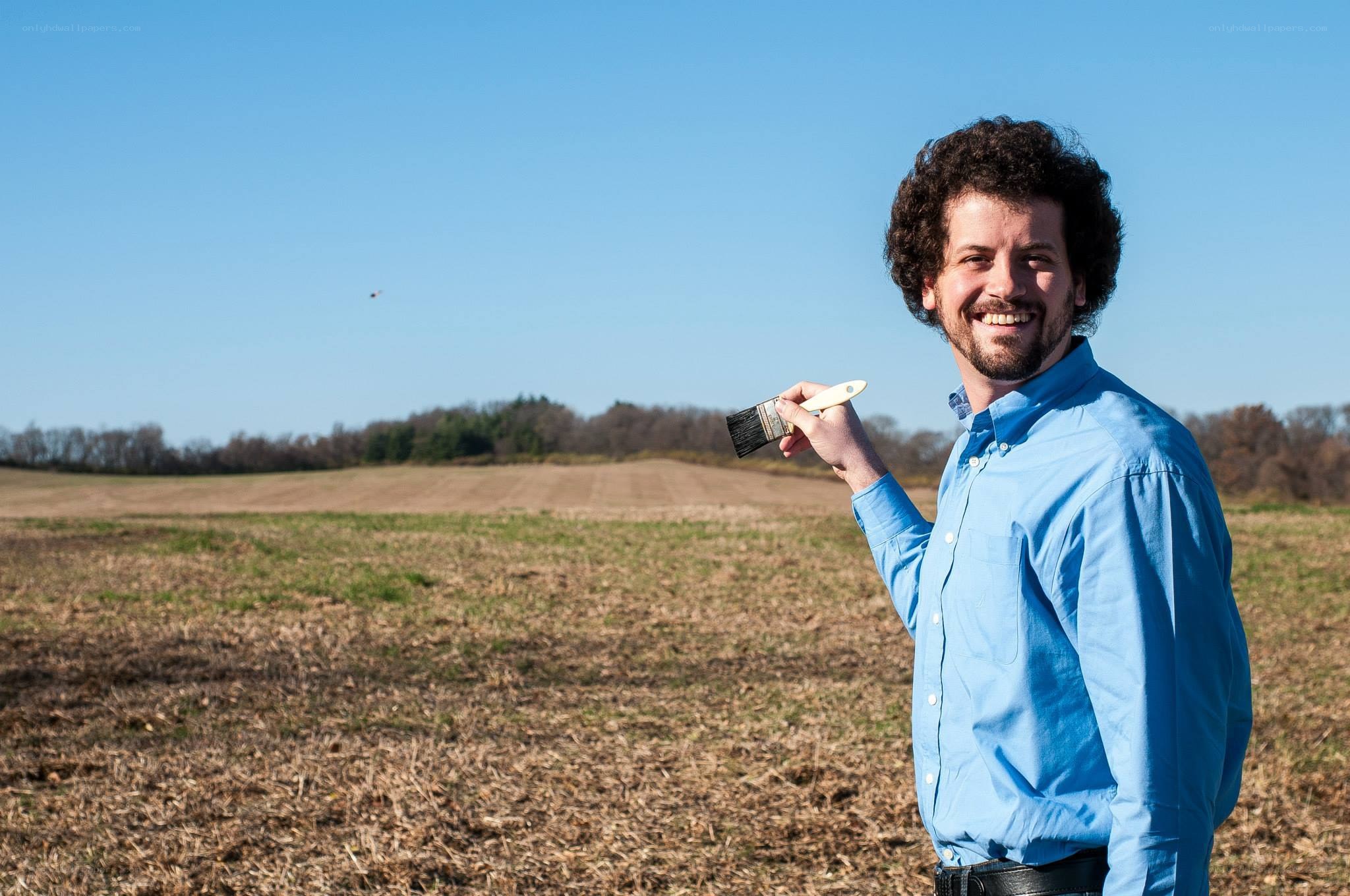 Man holding paintbrush in field