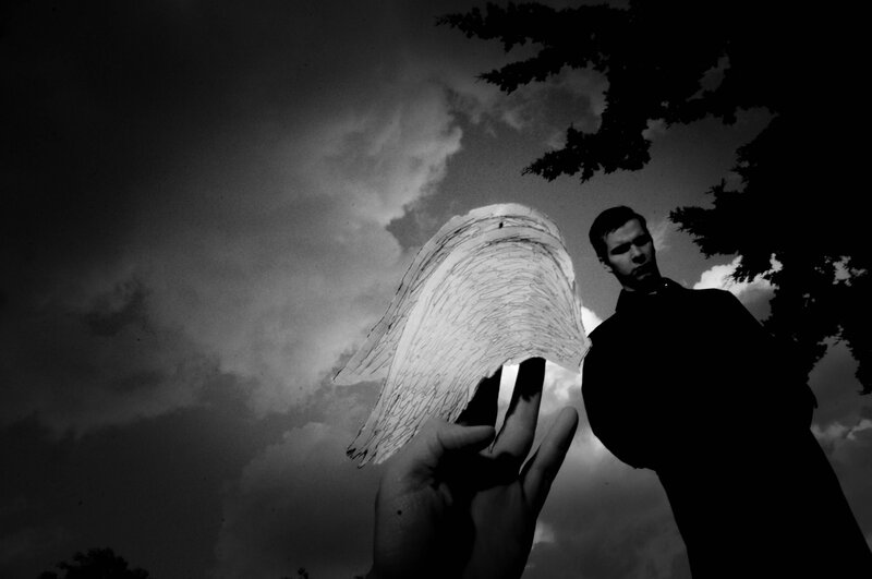 Man Holding Paper Wings — Black