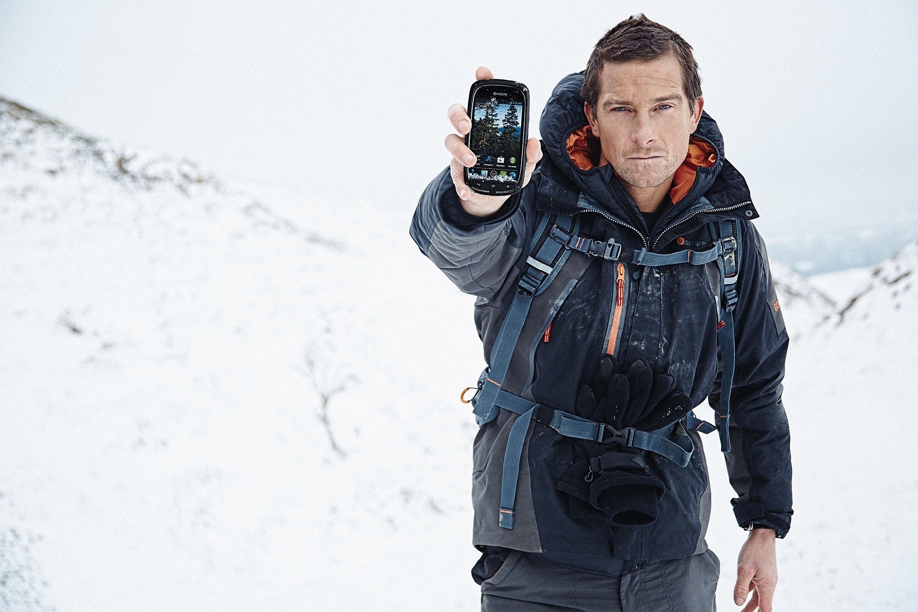 man holding phone in snow