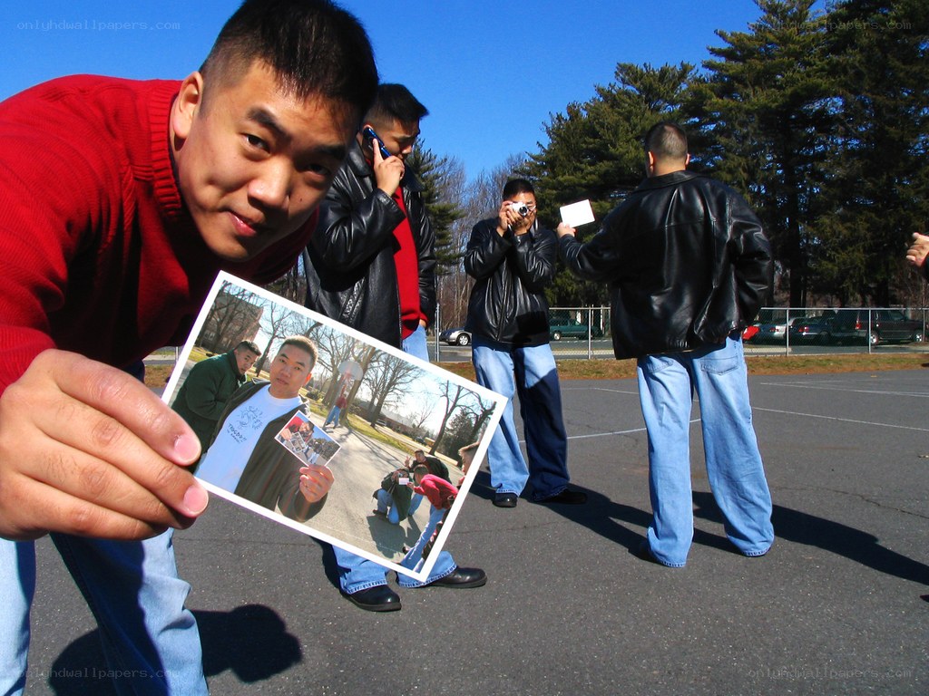 man holding photo outdoors