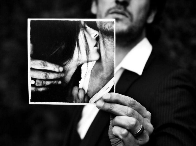 Man Holding Photograph — Black