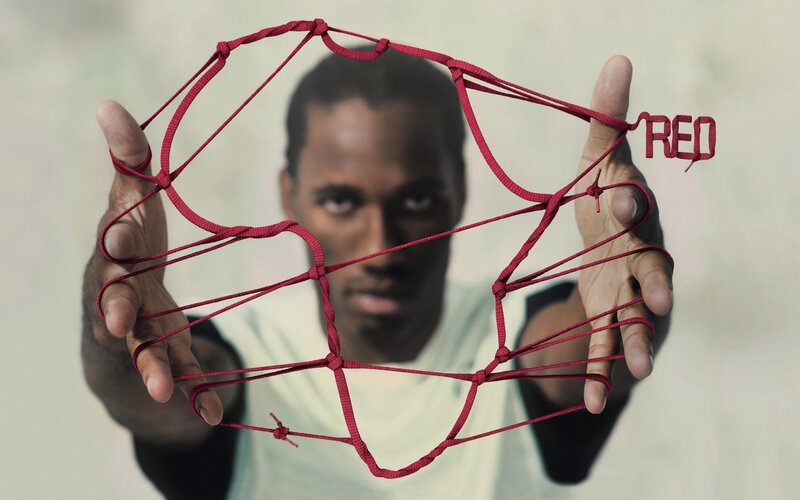 man holding red string net