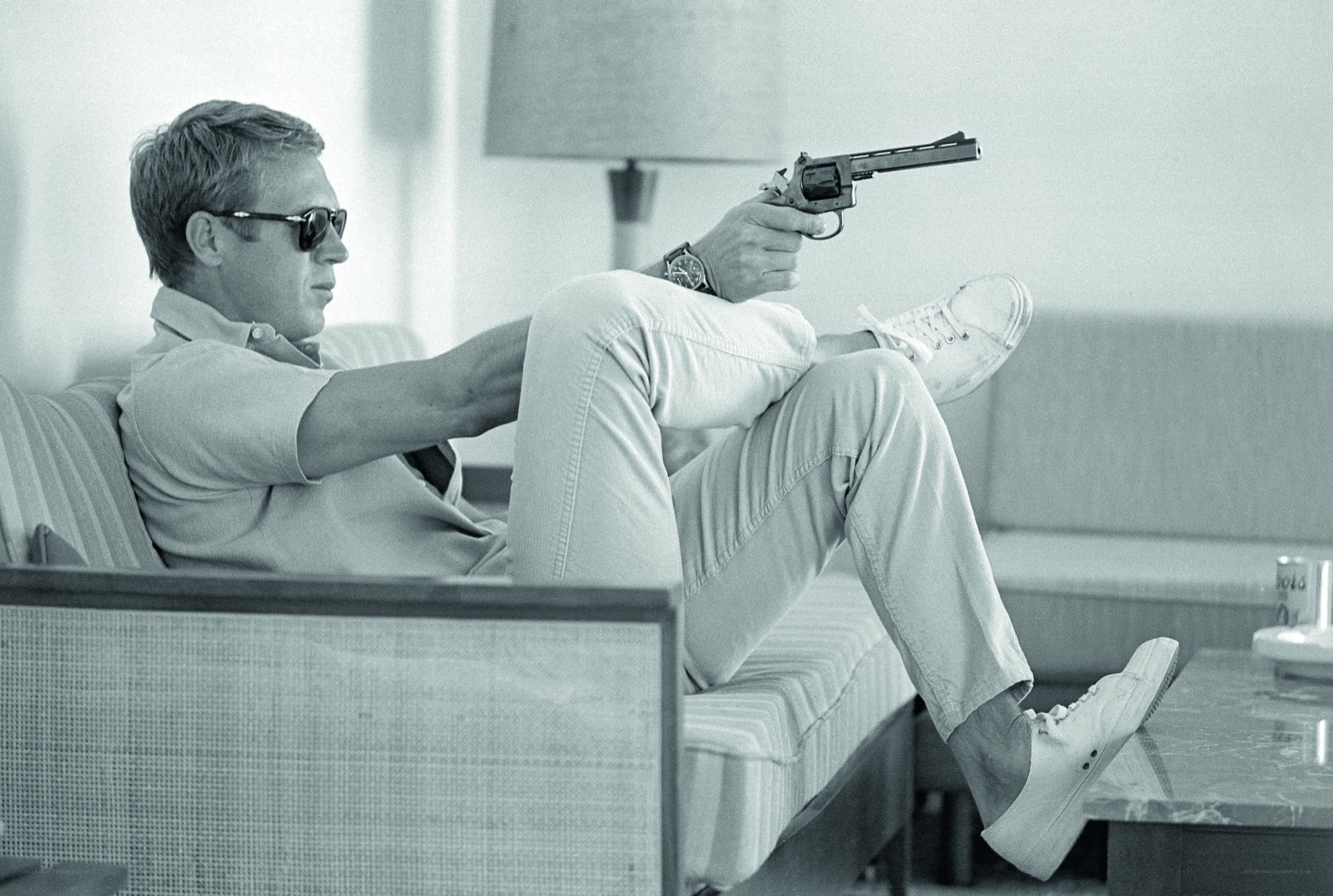 Man holding revolver on couch