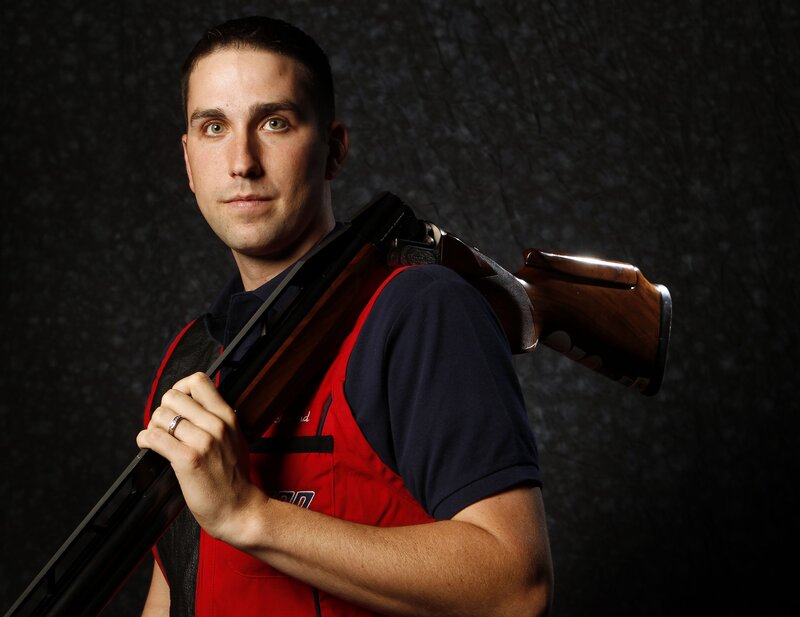 Man Holding Shotgun — Red, Serious