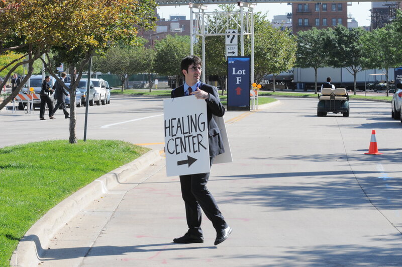 Man holding sign to healing center