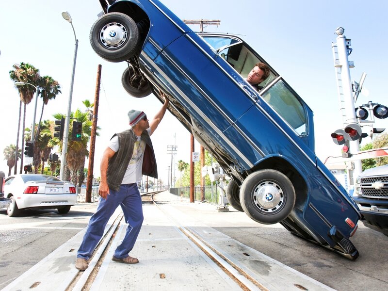 Man Holding Up Car