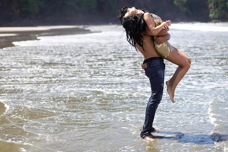 Man Holding Woman on Beach