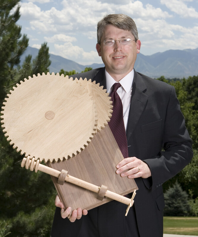 Man holding wooden gear mechanism