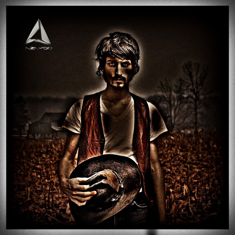 man in a field holding hat