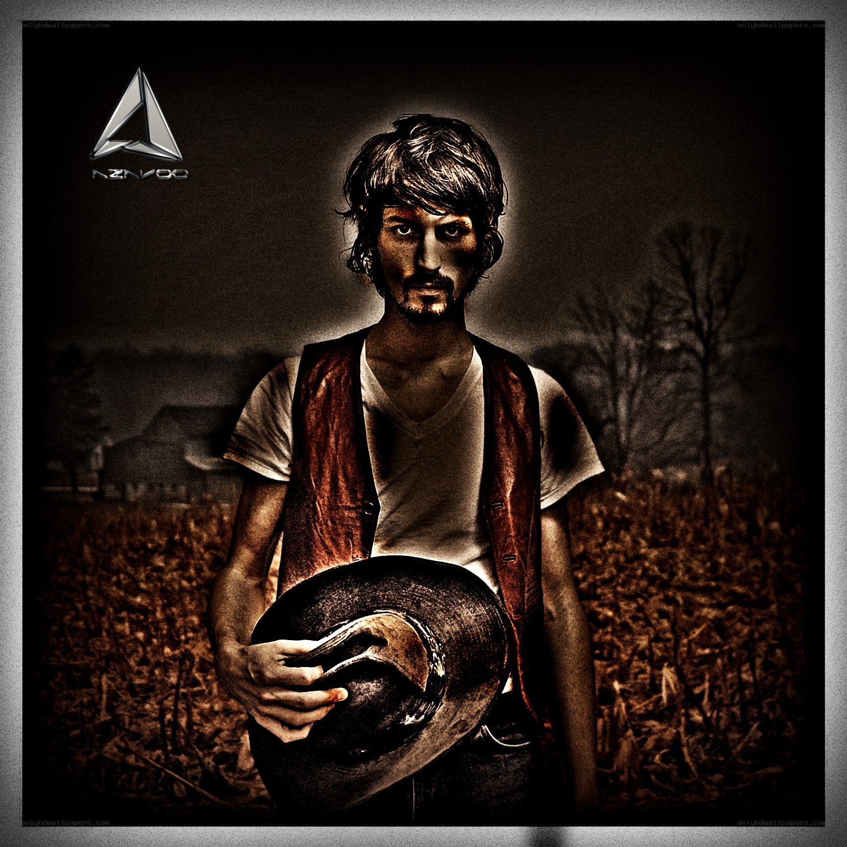 man in a field holding hat