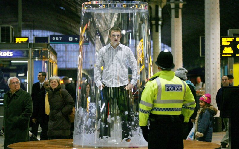 Man in a giant glass at train station