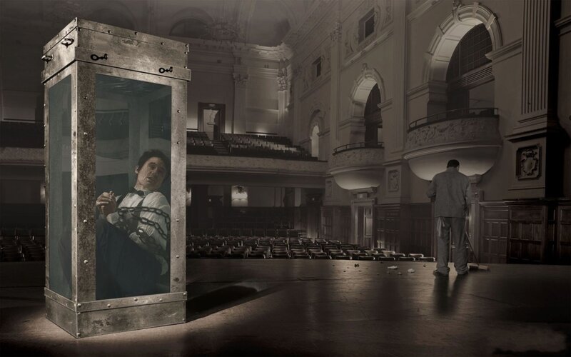 Man in a glass box on stage