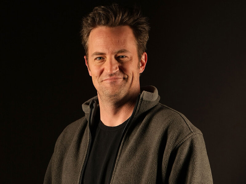 Man in a gray hoodie smiling
