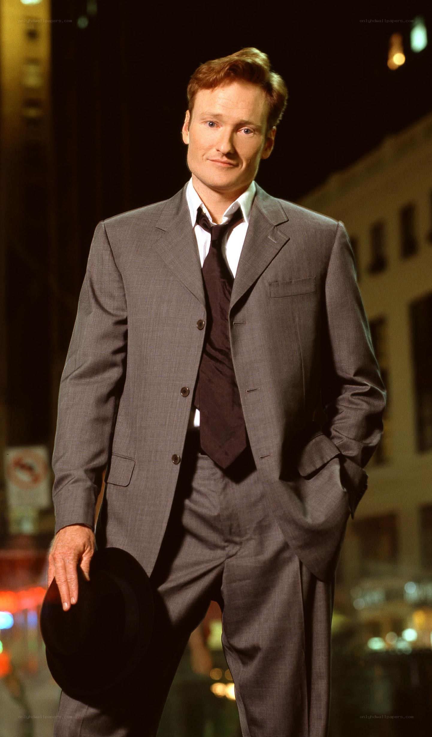 Man in a gray suit holding a hat