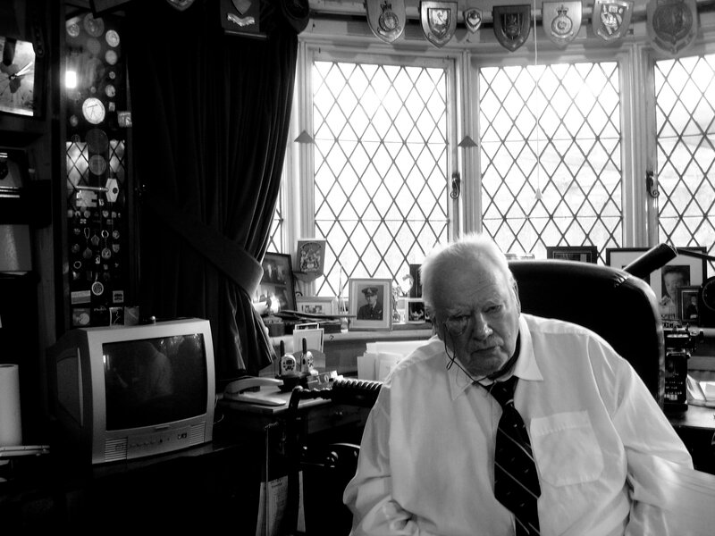 Man in a study with memorabilia