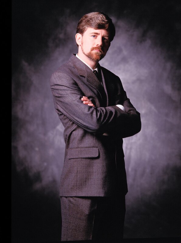 man in a suit with arms crossed