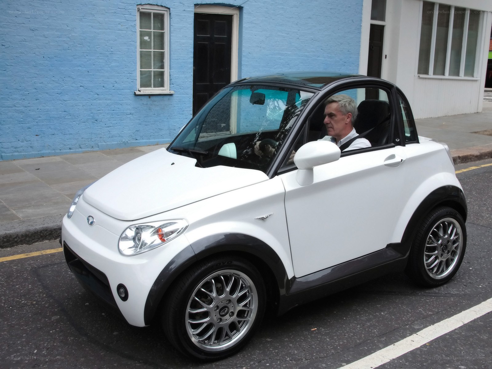 Man in a white microcar