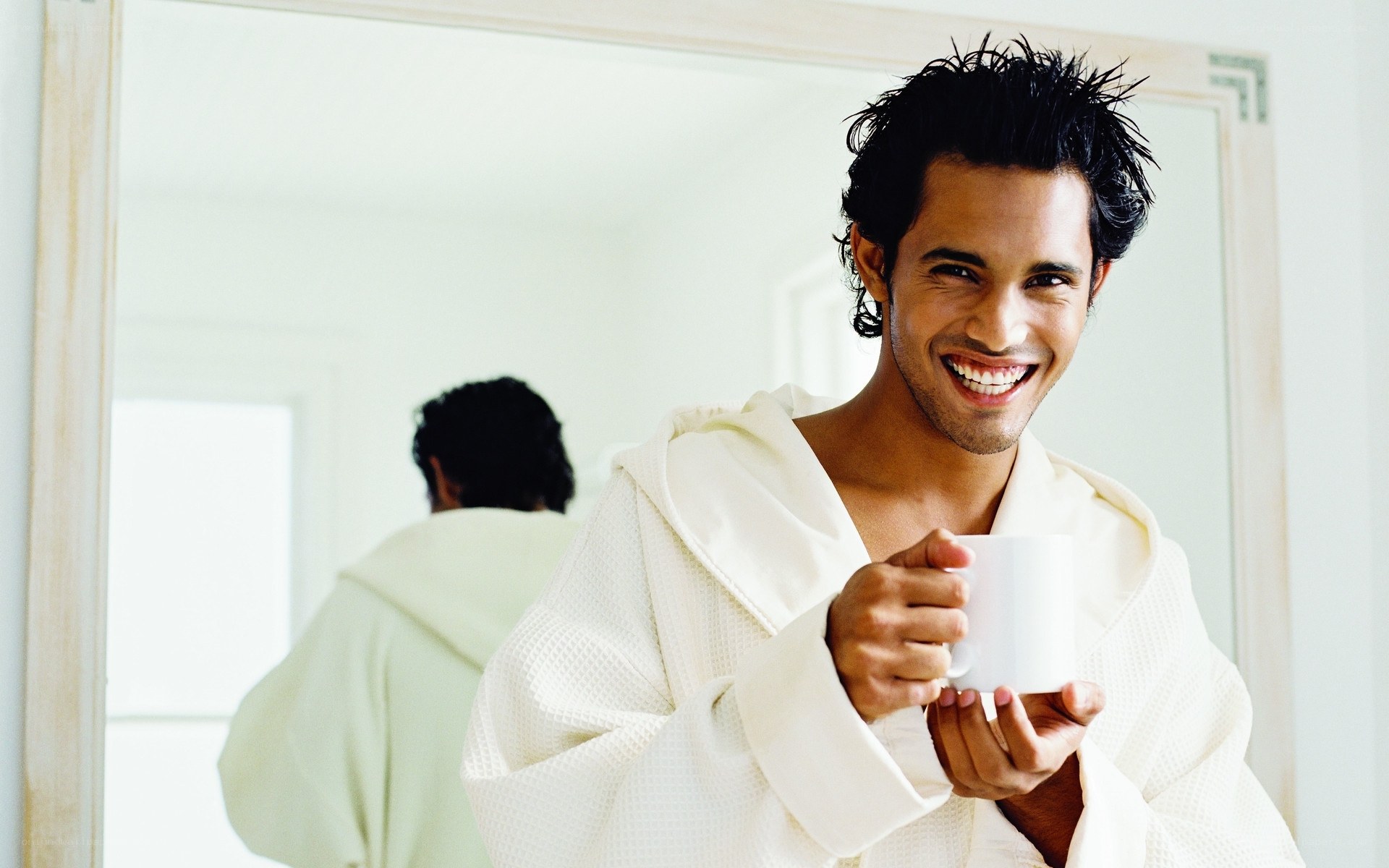 man in bathrobe holding cup