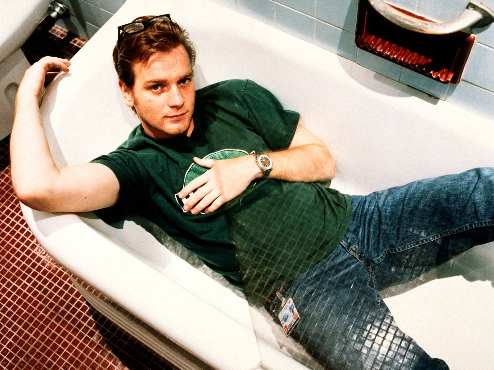 man in bathtub wearing green shirt