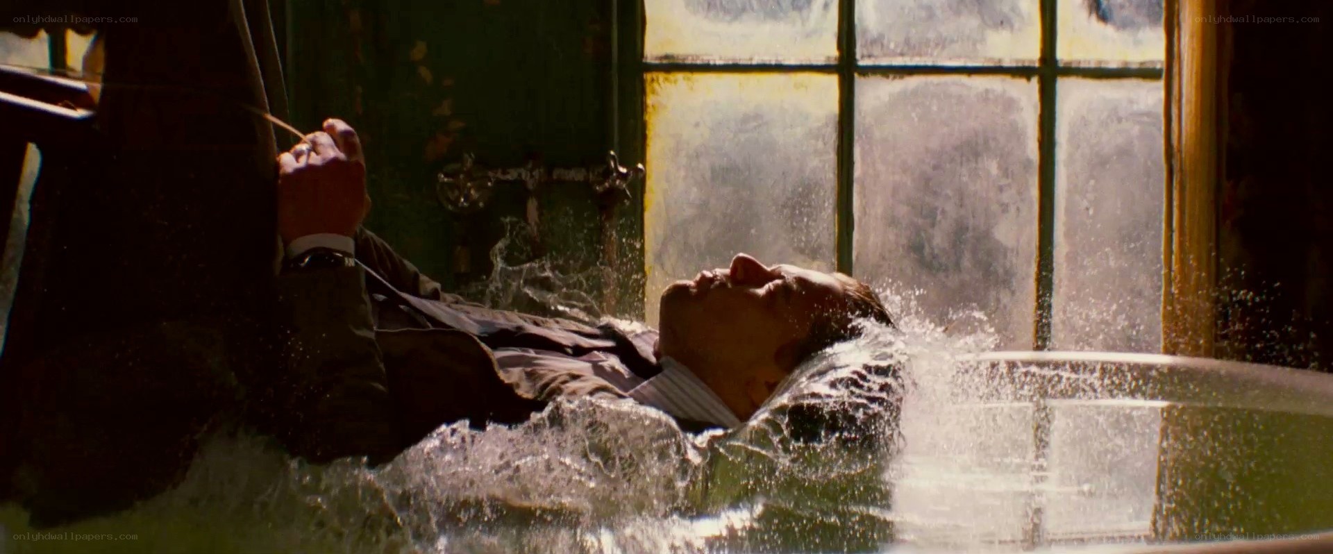 Man in bathtub with water splashing
