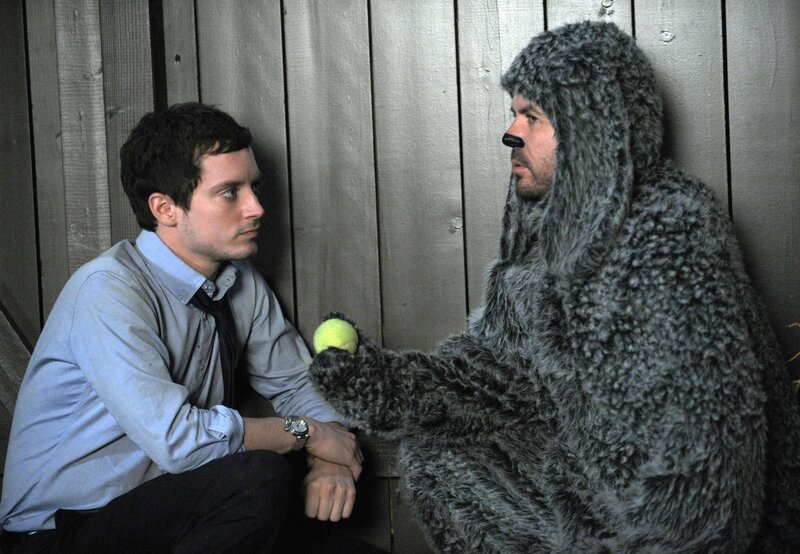 Man in bear costume with tennis ball