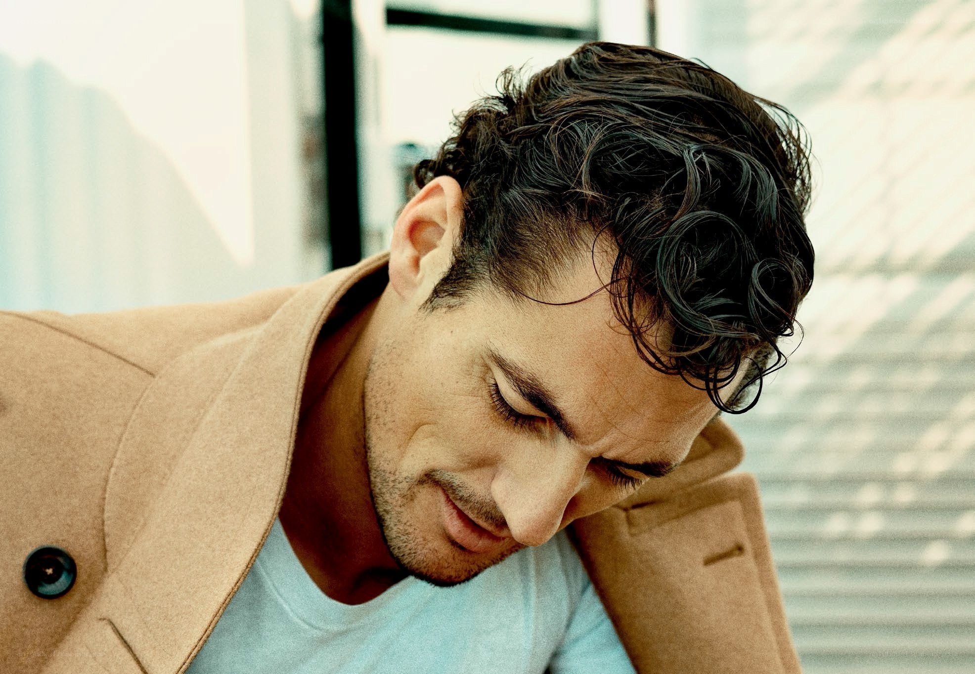 man in beige coat looking down