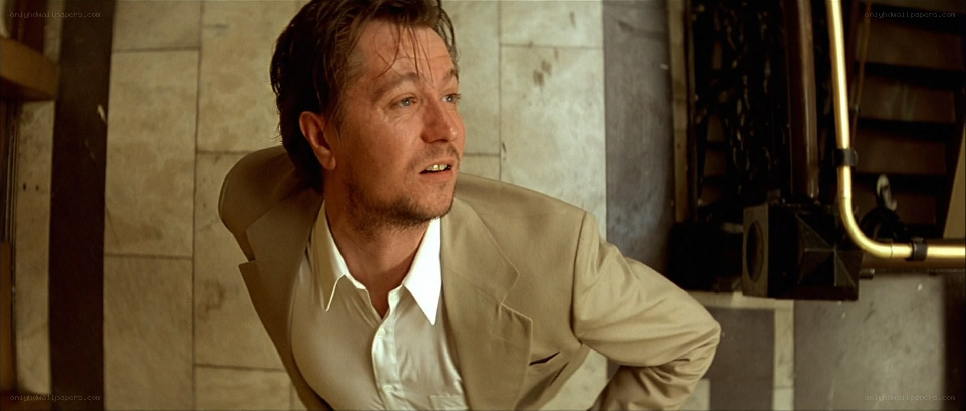 man in beige suit looking up