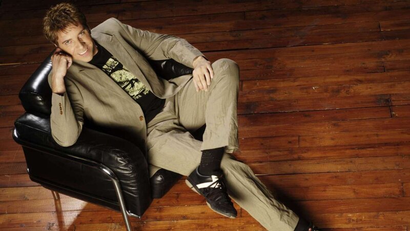 man in beige suit sitting