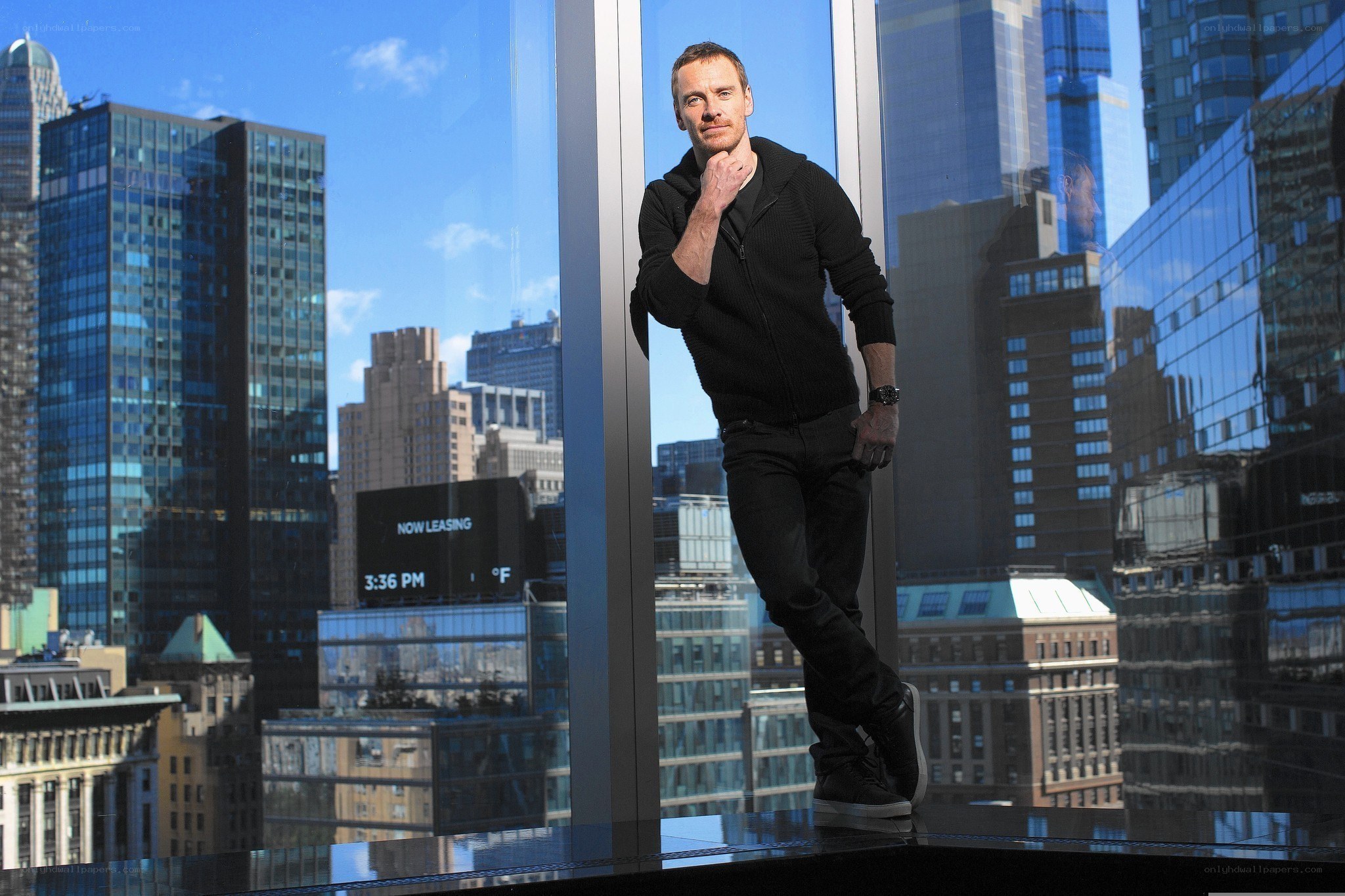 Man in black at city window
