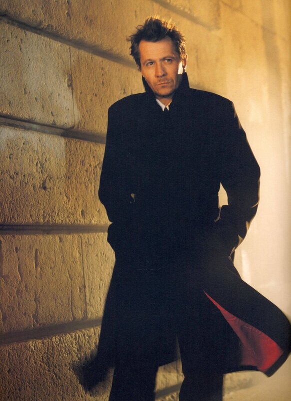 man in black coat against stone wall