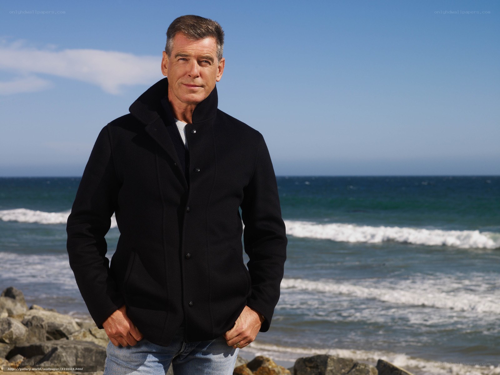 Man in black coat at beach