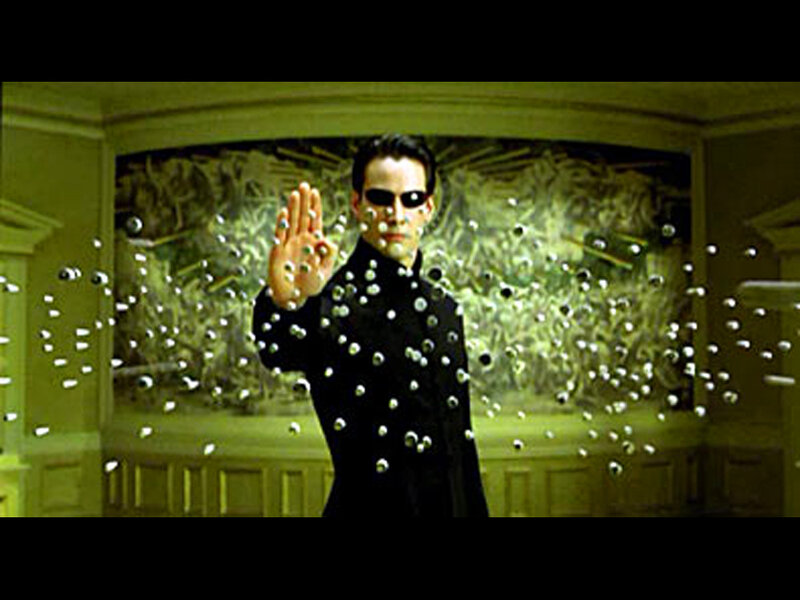 man in black coat stopping bullets