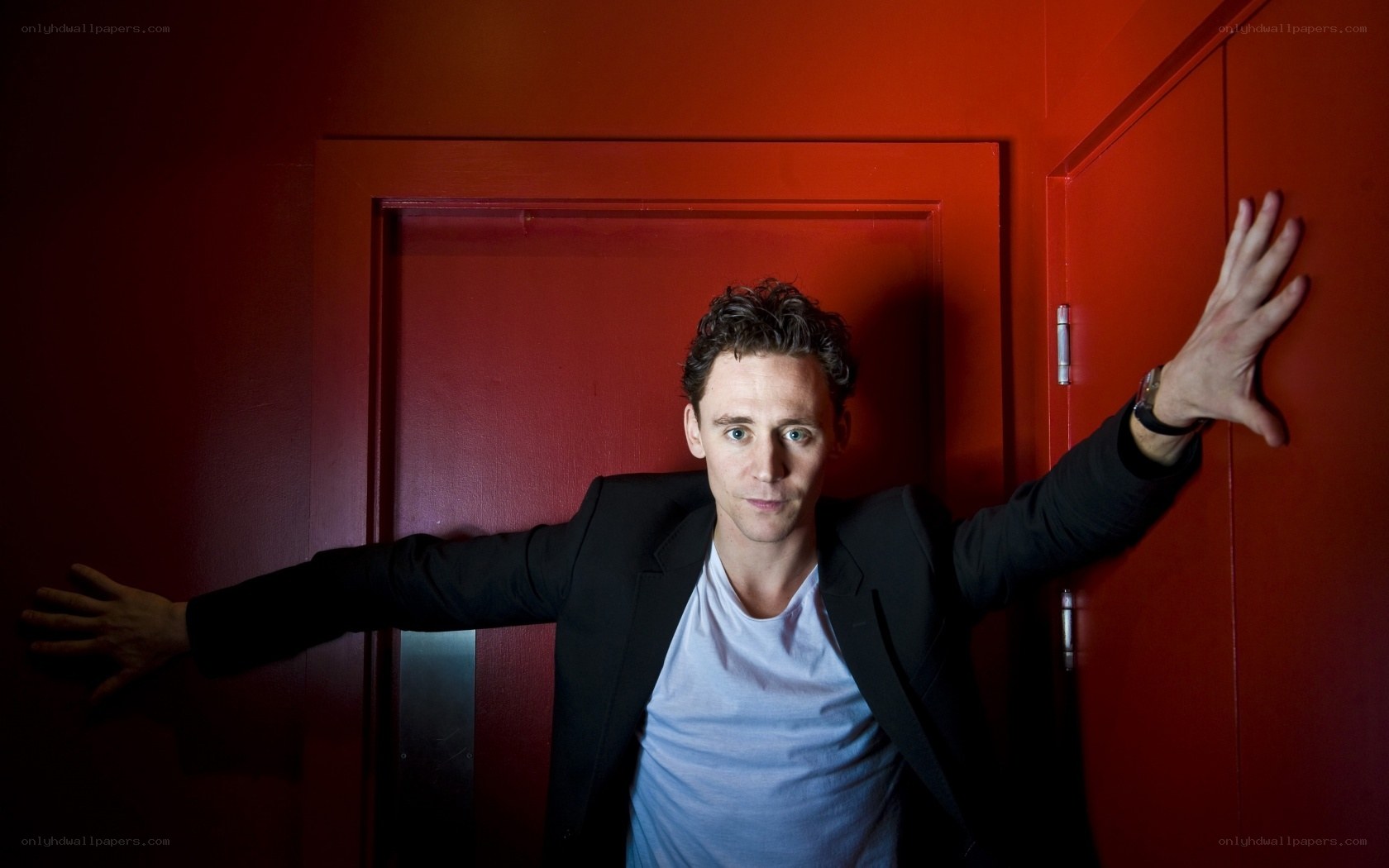 man in black jacket against red wall