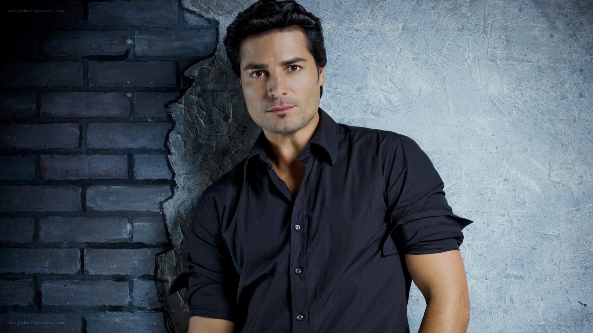 man in black shirt against brick wall
