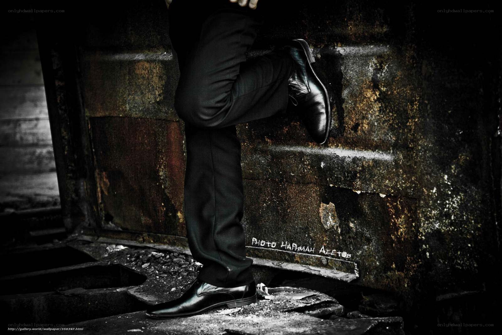 Man in black shoes on rusty wall