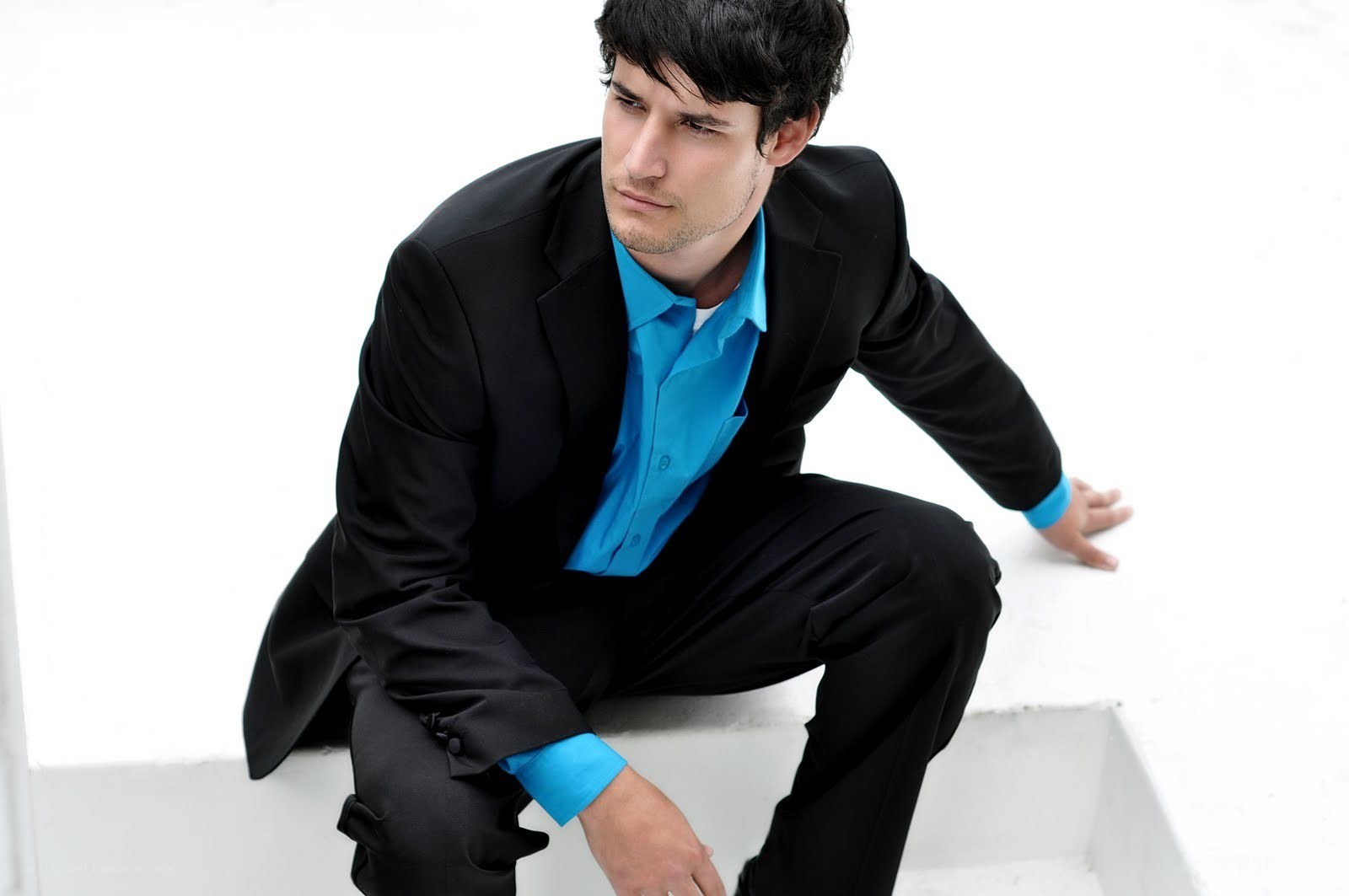 man in black suit crouching
