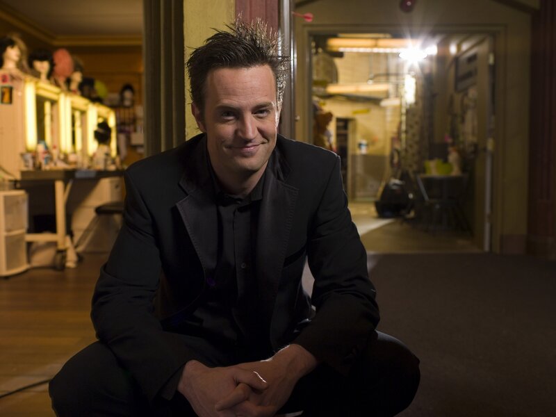 man in black suit crouching